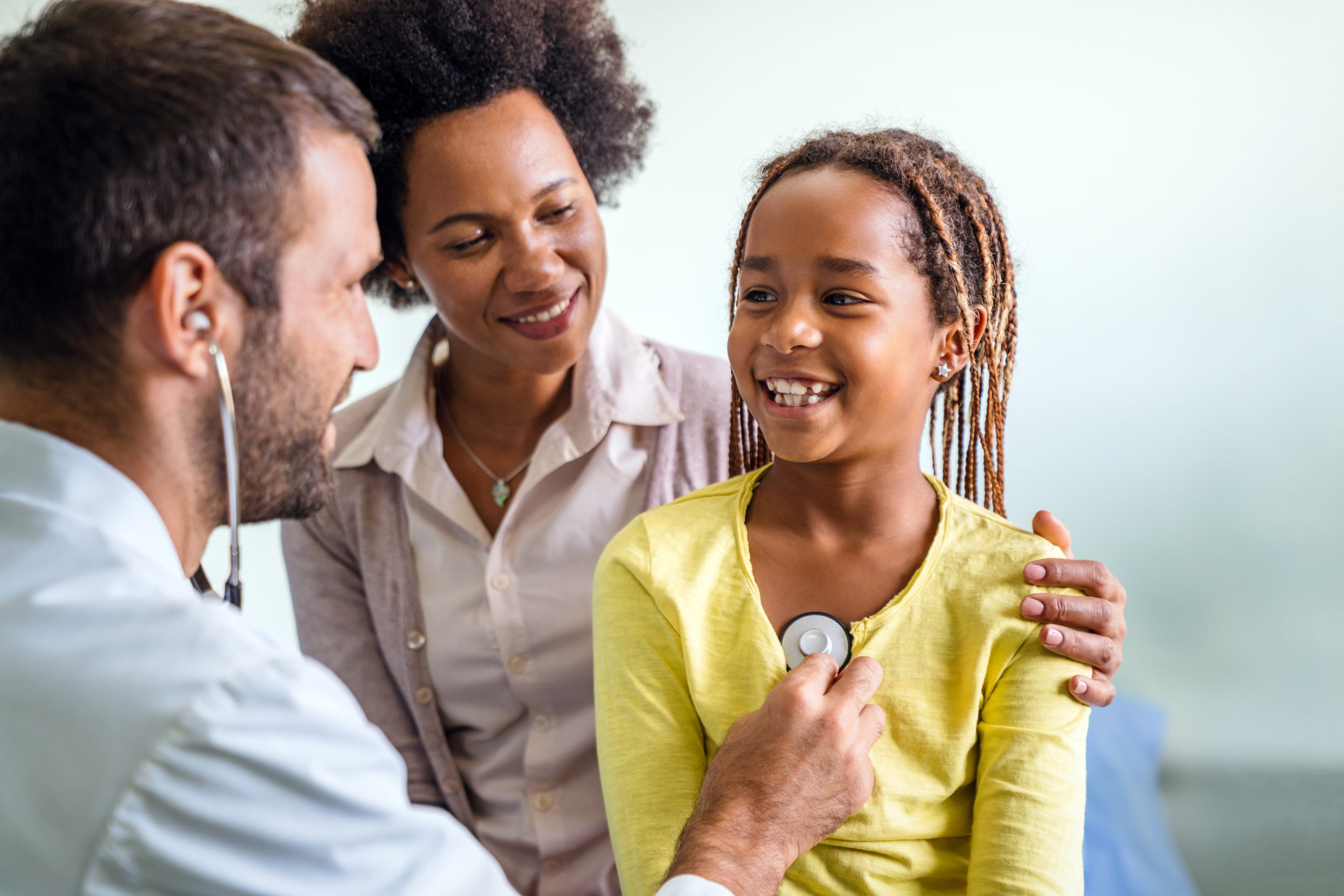 Healthcare medical exam people child concept. Close up of happy girl and doctor with stethoscope